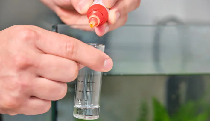 man testing ammonia levels in aquarium water